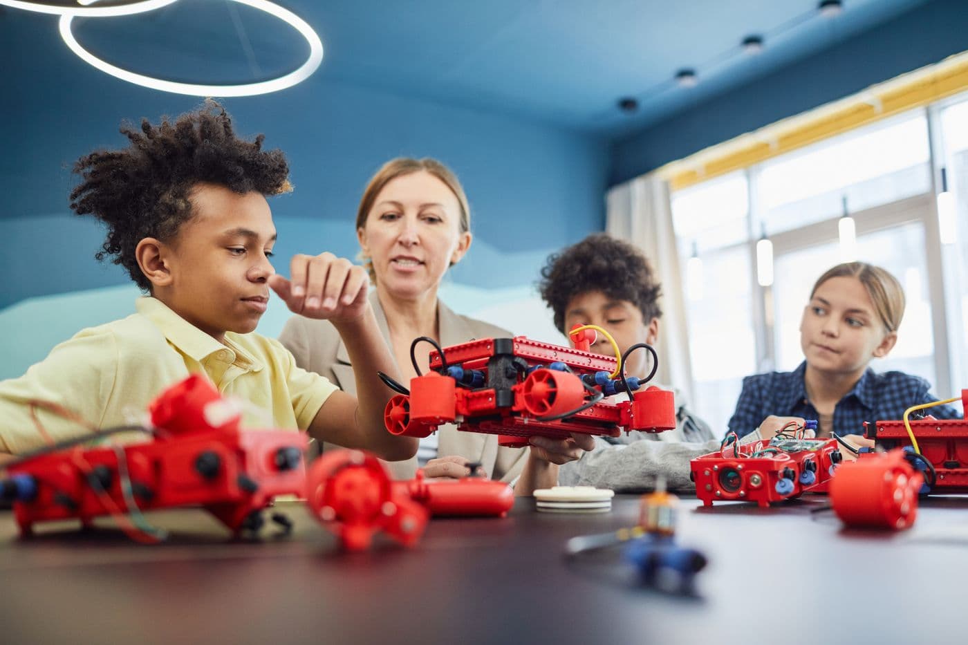Students and a teacher building robots together in a Genixotech robotics workshop